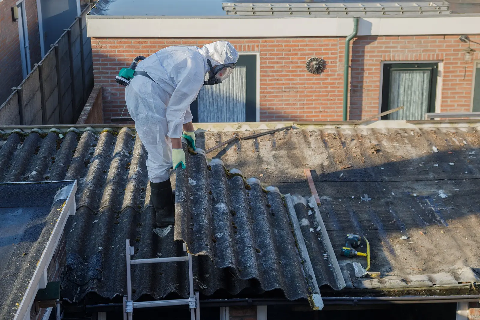 Professionelle Asbestentfernung, Asbestsanierung von Mann in Schutzkleidung